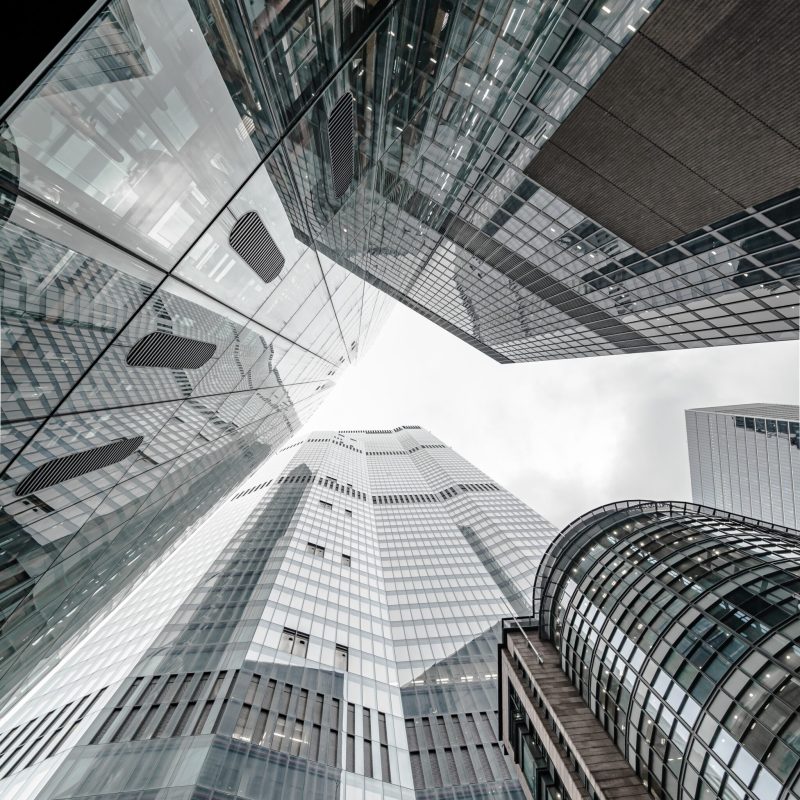 A vertical low angle shot of a modern business building scenery touching the sky